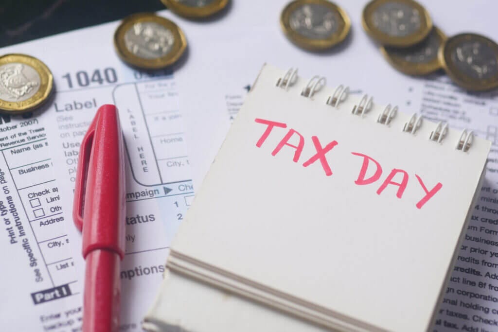 Formulario de declaración de impuestos y texto manuscrito del día de impuestos que son parte de como funcionan los taxes en USA