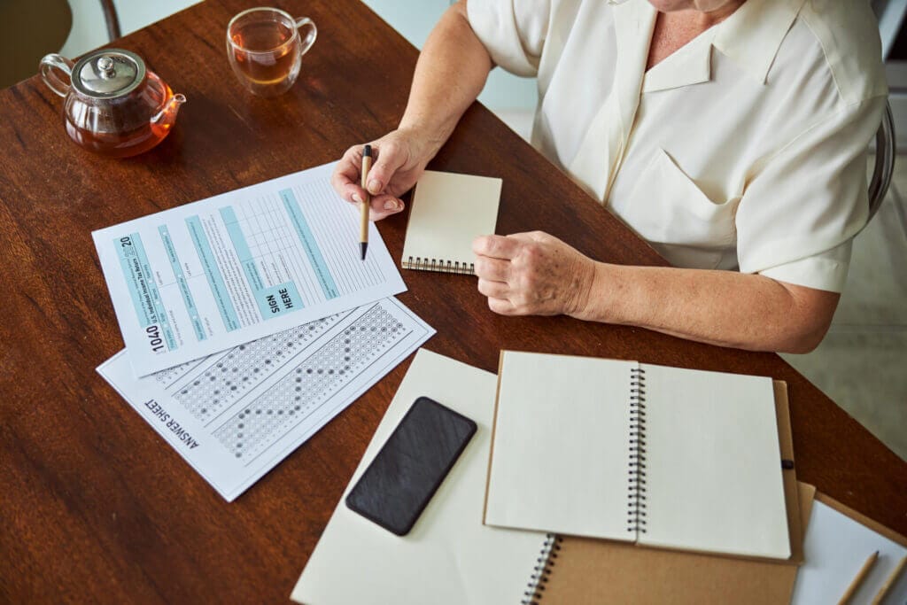Mujer anciana rellenando el formulario de como funcionan los taxes en USA